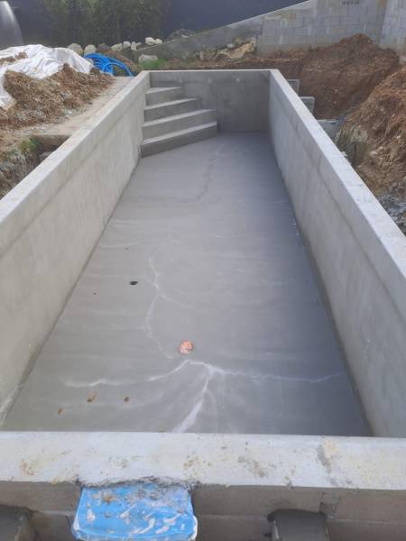 Construction d’une piscine traditionnelle maçonnée de 10x3 m , liner gris anthracite par DE MELO PISCINES à saint jean d’illac.