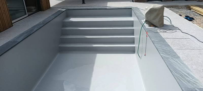 Jolie construction de piscine traditionnelle en PVC armé GRIS CLAIR par DE MELO PISICNES