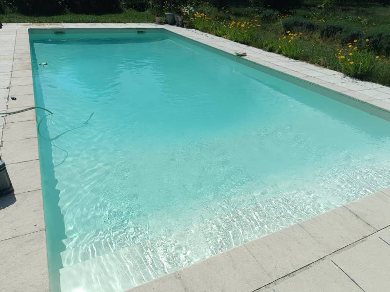 Pose d'un nouveau liner sable avec remplacement de la moquette de protection pour une rénovation durable et soignée.