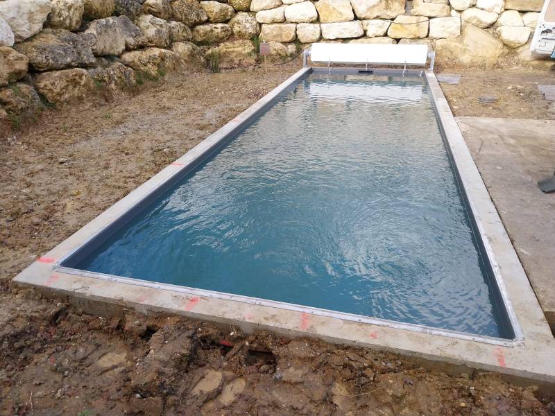 Construction d’une piscine traditionnelle maçonnée de 10x3 m , liner gris anthracite par DE MELO PISCINES à saint jean d’illac.