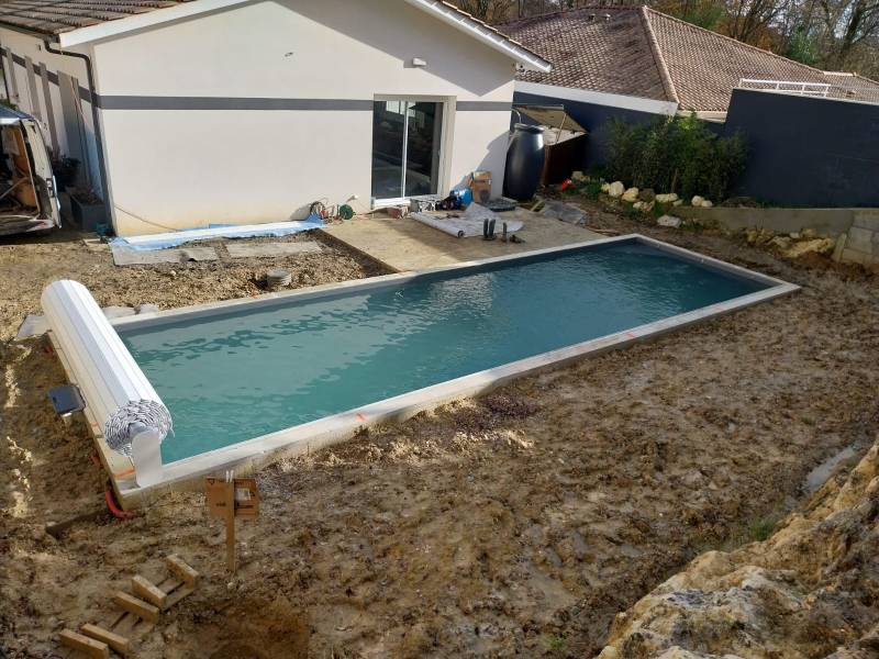 Construction d’une piscine traditionnelle maçonnée de 10x3 m , liner gris anthracite par DE MELO PISCINES à saint jean d’illac.